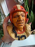 Front view of plaster football player bust showing helmet, facial features and number 13