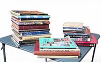 All books stacked on folding table, left and right stacks