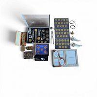 Top-down view of entire lot showing coin folders, watch case, nutcracker, brass pieces, pendants, porcelain knobs and spoon