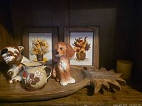 Overall lot showing bulldog figurine, spaniel figurine, strawberry creamer, wooden pineapple bowl, two framed crewel embroideries, candle