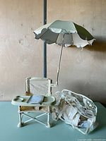 booster seat assembled with tray, umbrella attached, clear carry bag beside