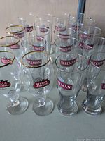 Group shot showing 20 branded beer glasses in two styles