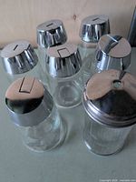 Seven glass shakers front angled view