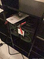 Pair of compact speakers on shelf with manual, cables and speaker wire visible