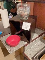 Cube shelf with glass vase and red bowl on counter