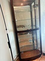Front angled view showing overall cabinet structure, glass shelves, and lighting fixtures