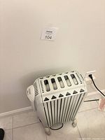 Full view of DeLonghi Dragon radiator showing body, casters and power cord