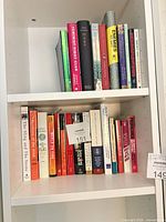 Two shelves of assorted books showing spines and dust jackets