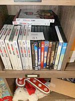 Shelf showing entire DVD lot with Big Bang Theory sets and assorted movie titles