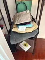 Overall lot on shelving with glitter handbag, teal gift bag and other items