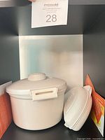 Steamer pot with lid alongside omelet cooker and box sleeves
