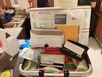 Overview of lot showing laser pointer cases, USPS boxes, HP paper, notebook, calculator