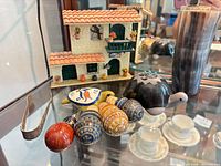 Close-up of stoppers, turtle, tongs, vase and house figurine