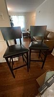 Front view of both black bar stools showing full design and height