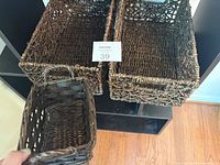 Two seagrass baskets side by side with wicker basket held in foreground