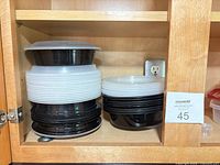 Stacks of black round containers with white lids
