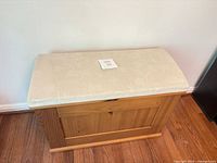 Front view of pine storage bench with upholstered seat