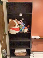Full front view of tall dark brown engineered wood bookcase with five shelves