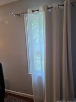 Curtain panels hung on rod over narrow window