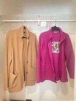 Both jackets hanging: beige Ann Taylor coat and magenta Bass Pro Shops fleece
