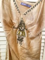 Beige satin sleeveless embellished top hanging