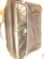 Front view of black nylon briefcase with leather panel and Tumi logo