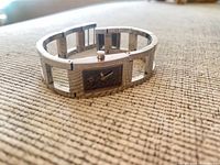 Front angled view showing stainless steel open-link bracelet and rectangular case