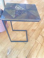 C-shaped side table showing wood top and metal frame