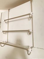 Front view of 3-bar over-door towel rack showing bars and hooks