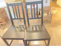 Front view of both black wood slat-back chairs