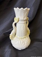Front view showing scalloped rim, molded body and serpentine handles