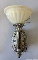 Front view of sconce showing alabaster shade and metal backplate