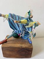 Left side view of three jester figures on wood block