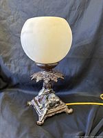 Full view of lamp unlit showing globe shade and camel base