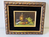 Front view of framed still life oil painting signed Bruger