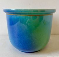 Side view showing turquoise-to-blue gradient glaze and rolled rim