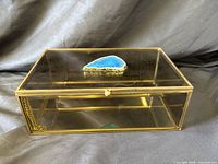Front and side view showing smoke glass panels, gold-tone frame, blue agate knob, interior chain