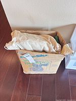 Exterior of worn Proctor Silex box with fabric drawstring bag on top