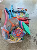 Overview of pool noodles, kickboards, bodyboard, discs, dive rings and accessories in crate