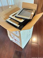 Cardboard box with stack of assorted frames