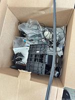 Overview of open box showing mounting bracket, cables, manual and accessories