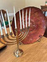 Menorah with candles beside glass charger on stand