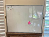 Front view of whiteboard mounted on wall with accessories attached