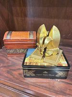 All three items grouped: pair of gold bookends, carved wood box, Lotus tin