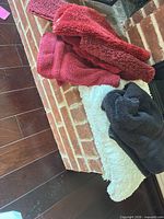 Lot overview showing red towel, dark gray towel and white shag mat