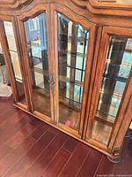 Front view showing four glass doors, wood frame, metal pulls, base moulding