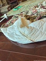View of cream floral comforter showing overall pattern and attached tags
