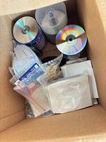 Box containing three spindles of blank CDs, sleeves, plastic sleeves and rubber bands