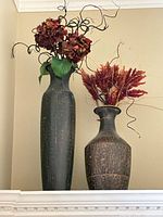 Both vases with floral stems on shelf