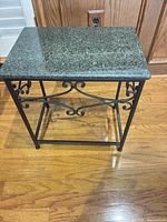 Front angle of end table showing granite top and wrought iron frame